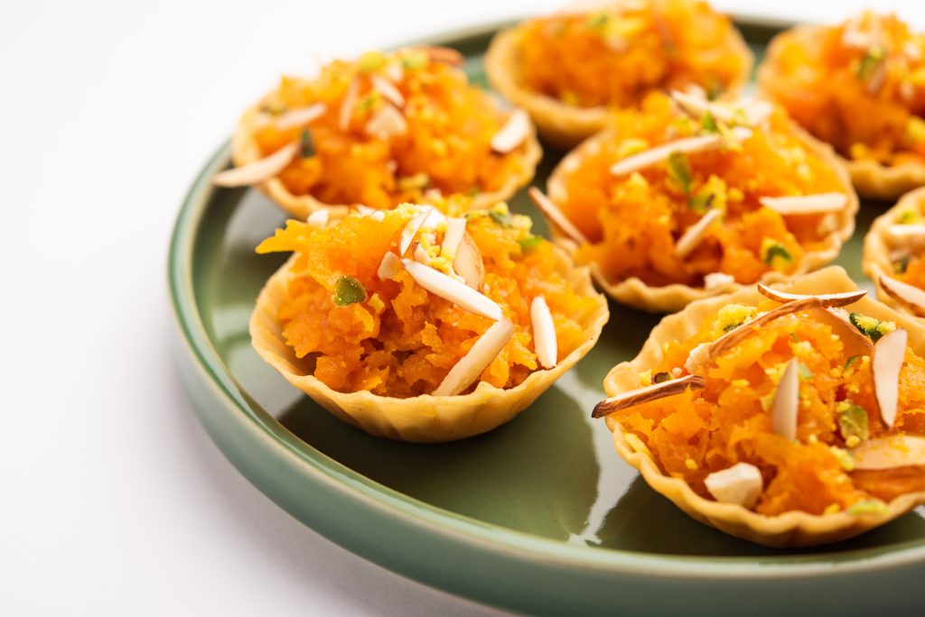 Carrot or Gajar Halwa canape or canapé or Fusion Tart, garnished with dry fruits. Indian dessert